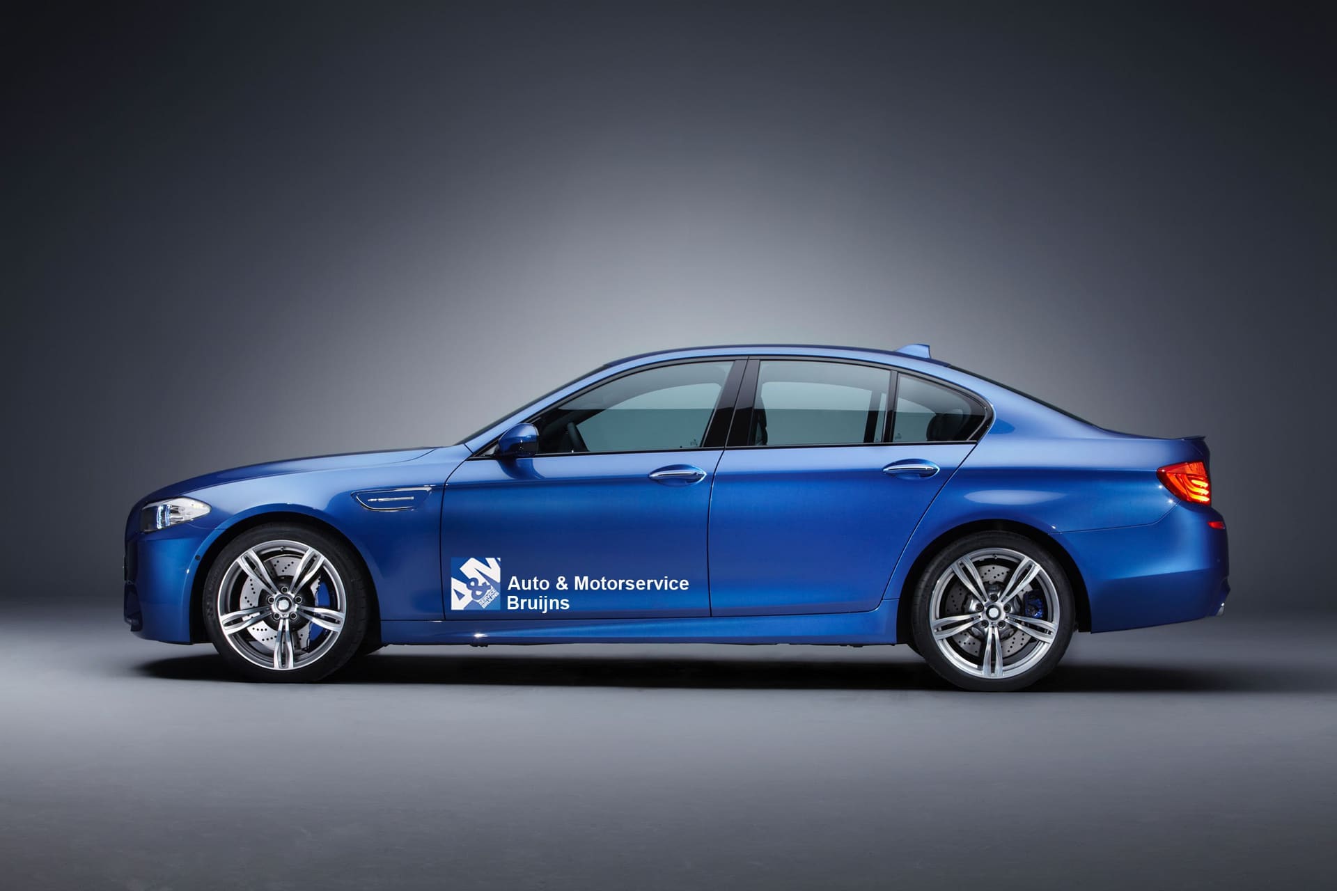 Blauwe BMW met de belettering van Auto en Motorservice Bruijns op de voordeur.